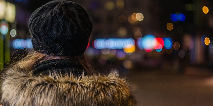 Lonely girl walking through night city street